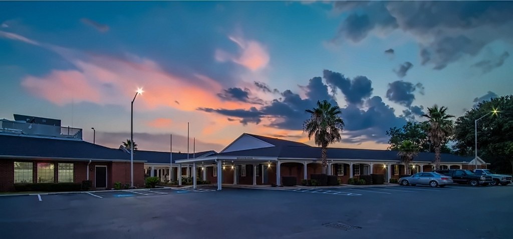 The front of Winton Inn & Suites under a sunset sky